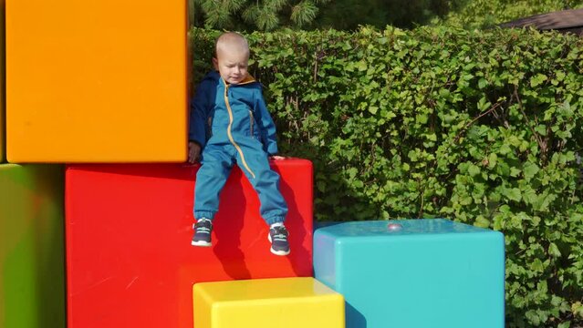 toddler child in amusement park, happy little boy climbing on colorful cubes. Divo Ostrov, St. Petersburg, Russia