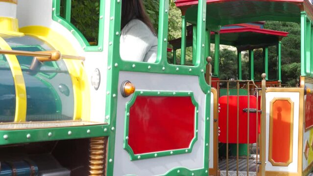 mother with toddler child in amusement park Divo Ostrov, St. Petersburg, Russia, attraction train Chukh-chukh