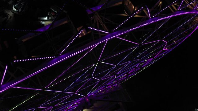 Aerial night view of the new ferris wheel located at Aztlan, Parque Urbano in Chapultepec, Mexico City. Drone tilting up as it flies away from the main subject.