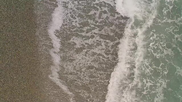 Calm Ocean Waves from Above with a Top Down View Over a Pebbled Beach in Looc Bay, Philippines. 