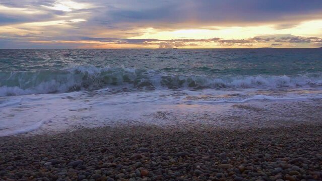 Ocean Waves with a Sunset Scenic View of the Horizon Over a Pebbled Beach in Looc Bay, Philippines.