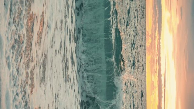Vertical Angle Sunset Ocean Waves Over a Looc Bay Beach with Turquoise Waters in the Philippines. 