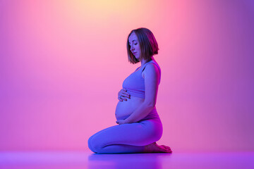Obraz na płótnie Canvas Sporty pregnant woman sitting against color background