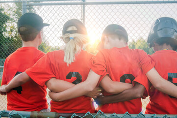 A 10 year old girl with her teammates in the dugout