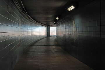 Photo of a dark, curving underpass.