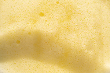 yellow bubbles of fruit drinks froth. Above view.