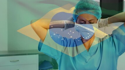 Animation of waving brazil flag against biracial female surgeon wearing surgical mask at hospital - Powered by Adobe