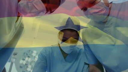 Animation of waving ghana flag against team of diverse surgeons performing operation at hospital - Powered by Adobe