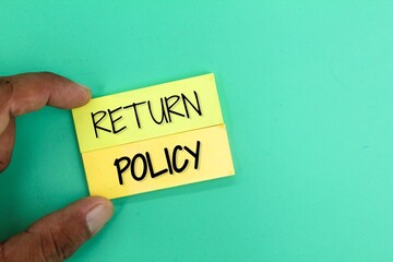 hand holding colored paper with the word RETURN POLICY. policy concept