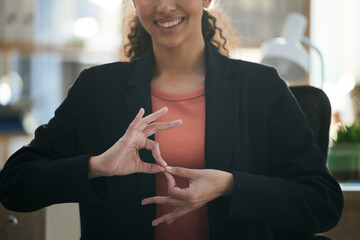 Hand gesture, corporate and woman at work for communication, sign language or working. Smile, office and employee, person or worker gesturing for conversation, talking or connection in the workplace © Talia Mdlungu/peopleimages.com