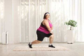 Corpulent woman in sportswear stretching legs