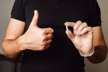 blue yellow capsule pill in hand
