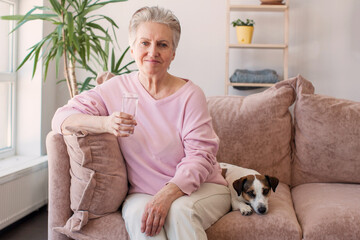 Mature Woman Drink Water on sofa at home