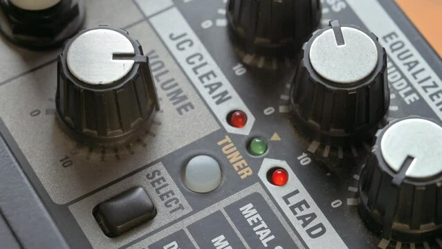 Man adjusting volume knob on guitar amplifier. 4k video footage UHD 3840x2160