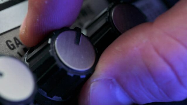 Man adjusting volume knob on guitar amplifier. 4k video footage UHD 3840x2160
