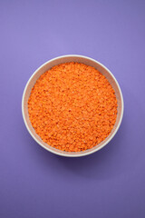 uncooked Red lentils in white bowl on ceramic