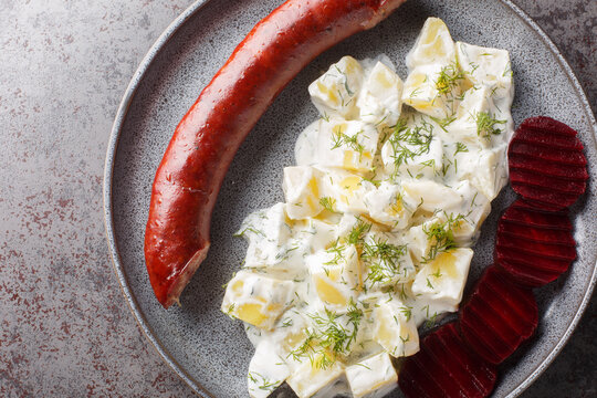 Swedish Lard Sausage Isterband with potatoes in cream sauce with dill and boiled beets close-up on a plate on the table. Horizontal top view from above