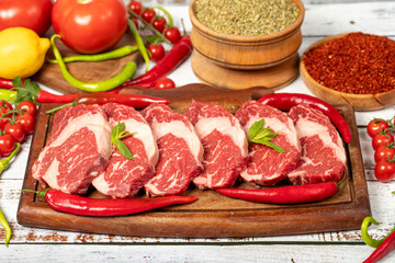 Veal entrecote meat on wood background. Raw beef rib eye steak with herbs and spices