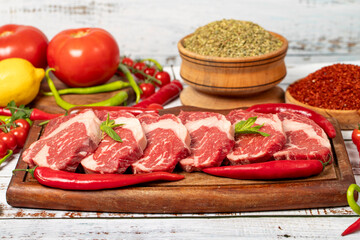 Veal entrecote meat on wood background. Raw beef rib eye steak with herbs and spices. Close up