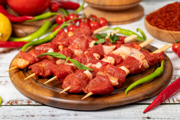 Beef tenderloin skewer on wood background. Beef tenderloin skewer with raw sauce with herbs and spices. Close up