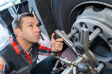 a man checking a bus tyre