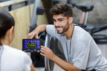 handsome coach training woman on the exercise rowing machine © auremar
