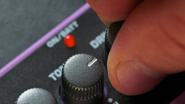 Man tuning knobs on guitar pedal effect. 4k video footage UHD 3840x2160