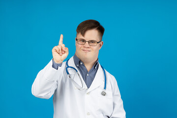 Smiling young man with cerebral palsy wearing glasses in doctor uniform with stethoscope. World...