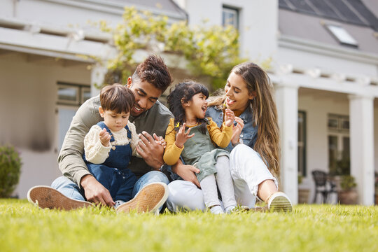 Happy family, parents and children for picnic, relax and games on grass or garden outdoor in summer. Love, people and kids at home on ground for care, freedom and bonding in nature or environment