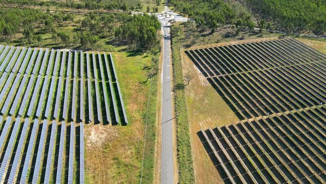Flying over a car on a road surrounded by solar panels,Portugal
