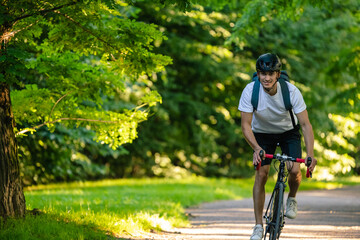 Naklejka premium Young athlete on a bike in the sunny summer park