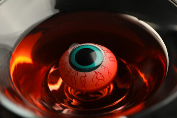 Decorated eye in glass with liquid, halloween concept