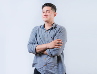 Portrait of smiling latin man with arms crossed isolated. Young casual latin man smiling at camera....