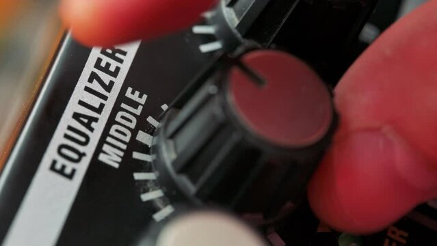 Man tuning equilizer knob on guitar amplifier. 4k video footage UHD 3840x2160