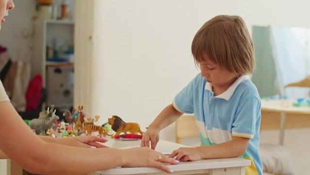 A skilled pedagogue creates a joyful classroom filled with colorful letters, nurturing children's language development.