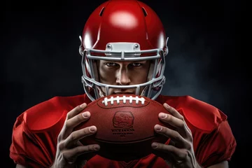Fotobehang American football player in red uniform holding ball. Studio shot over black background. American football player in helmet holding a rugby ball, AI Generated © Iftikhar alam