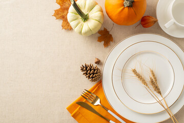 Harvest-themed tabletop setting: Top view of plates, cup, cutlery, orange napkin. Embellished with pumpkin, pattypan, wheat, seasonal items on pastel beige tablecloth. Empty area for text or ad