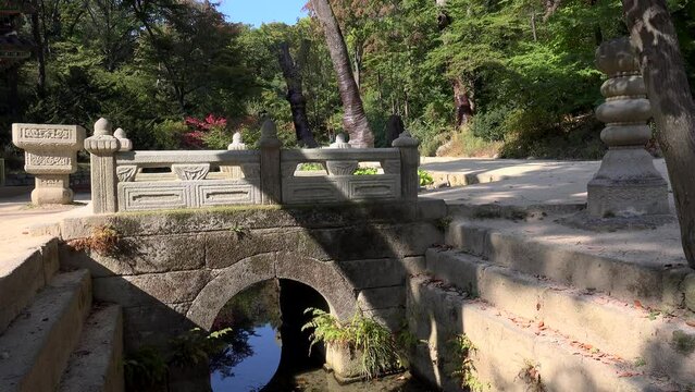 Stone Bridge across the pond at the Huwon (Secret Garden) of the Changdeokgung Palace. Seoul, South Korea