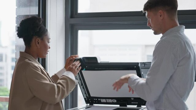 Businessman and woman photocopying paperwork in office.  Two businesspeople using printer machine together in office. Business and technology concept