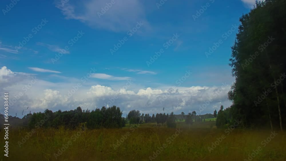 Aufkleber fast moving clouds across the countryside fields of latvia of a motion timelapse.