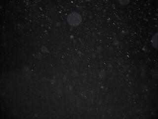 Abstract background image, blurred, bokeh, raindrops, black background.