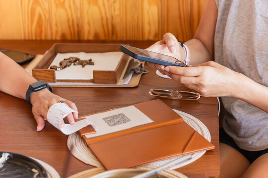 Woman customer paying food via mobile phone.