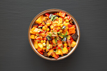Homemade Eggplant Potato Tomato Stew with Parsley in a Bowl on a black background, top view.