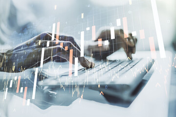 Multi exposure of abstract financial graph with world map and with hand typing on laptop on background, financial and trading concept