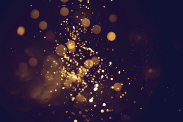 Golden abstract bokeh on black background. Celebrating Christmas, New Year or other holidays. - obrazy, fototapety, plakaty