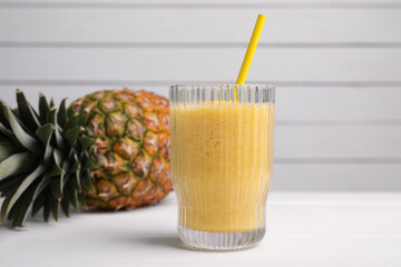 Tasty pineapple smoothie and fresh fruit on white table