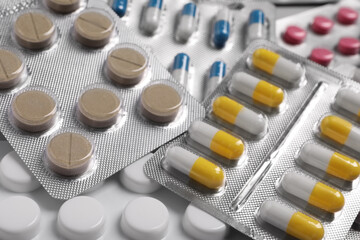 Many different pills in blisters as background, closeup