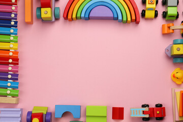 Frame of different children's toys on pink background, flat lay. Space for text