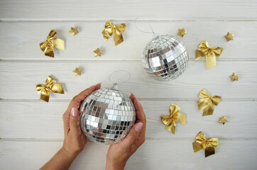 A large Christmas mirror ball is in women's hands