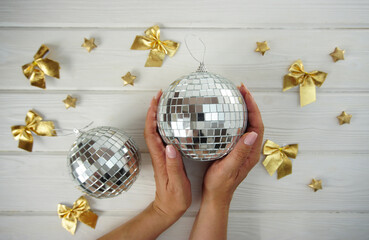 A large Christmas mirror ball is in women's hands